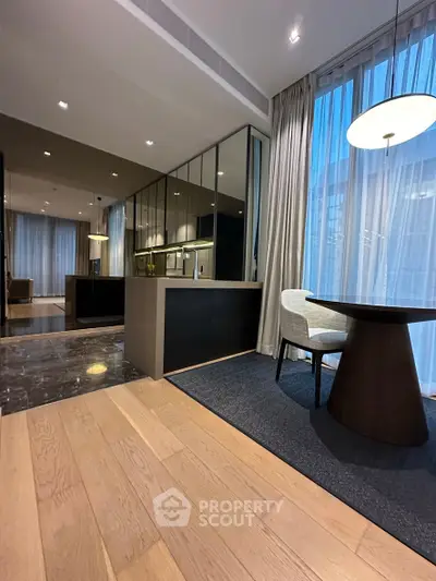 Modern open-plan kitchen and dining area with sleek design and floor-to-ceiling windows.