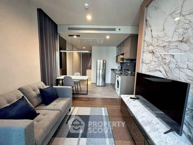 Modern living room with stylish decor, open kitchen, and sleek appliances in a contemporary apartment.
