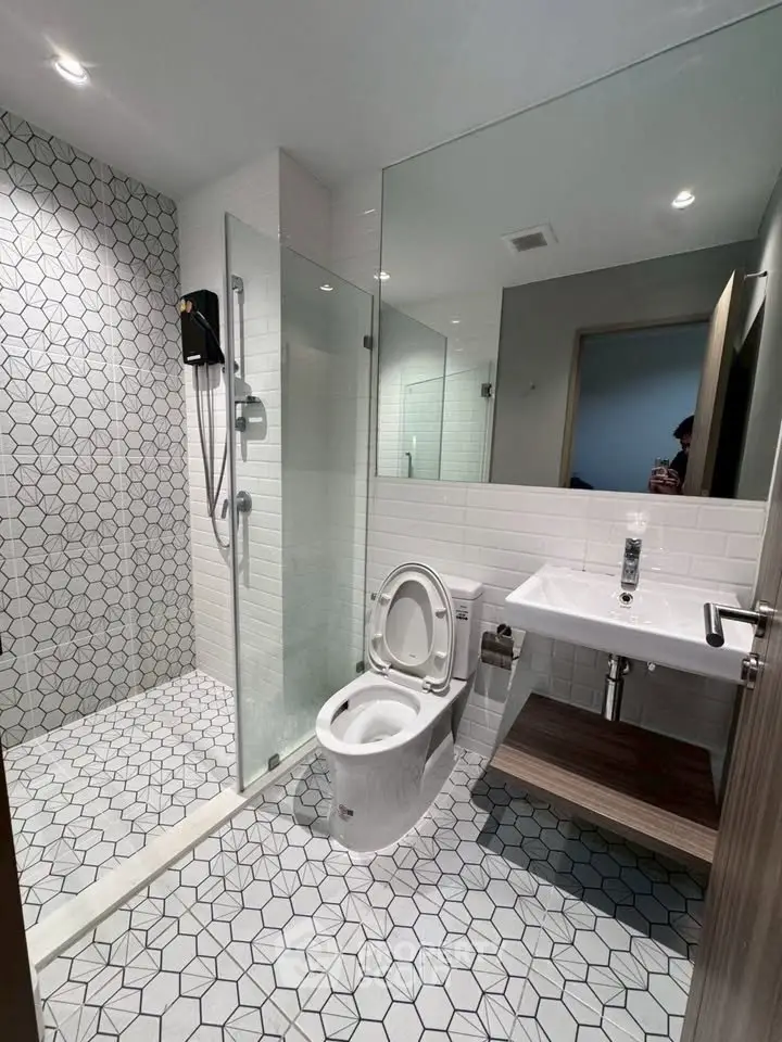 Modern bathroom with glass shower and geometric tile design