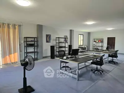 Spacious modern office space with desks, chairs, and shelving, ideal for productivity and collaboration.