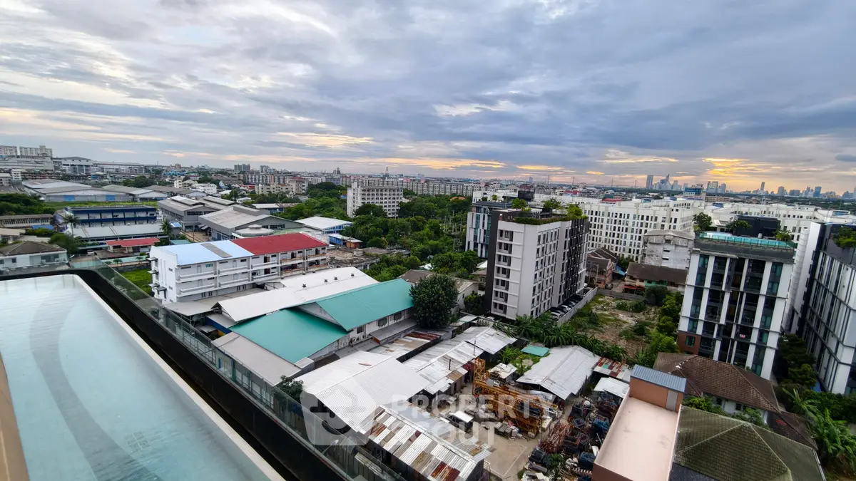 Stunning cityscape view from high-rise balcony showcasing urban skyline and vibrant sunset.