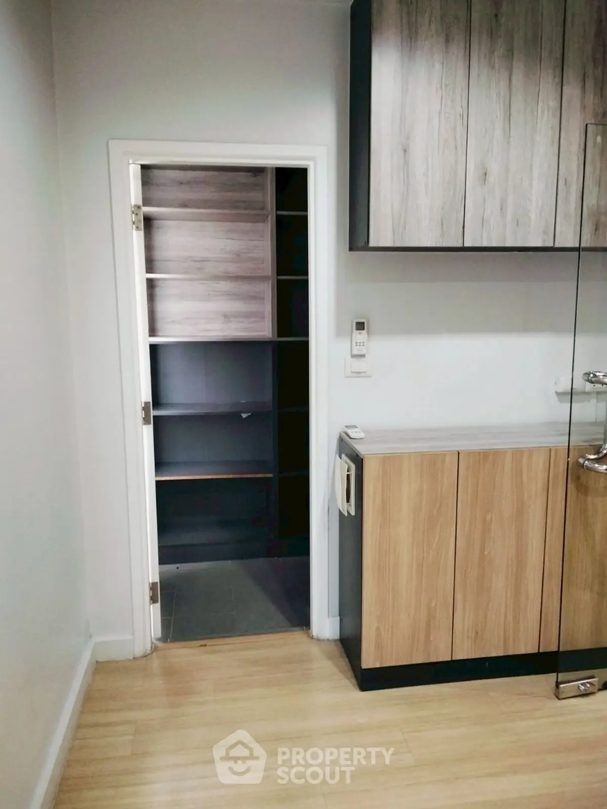 Modern kitchen with wooden cabinets and open pantry door