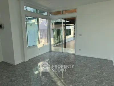 Spacious corner unit with large windows and modern flooring in a bright interior space.