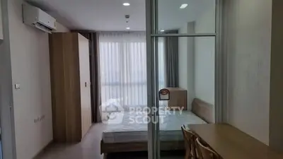 Modern bedroom with large window and wooden furniture in a stylish apartment.