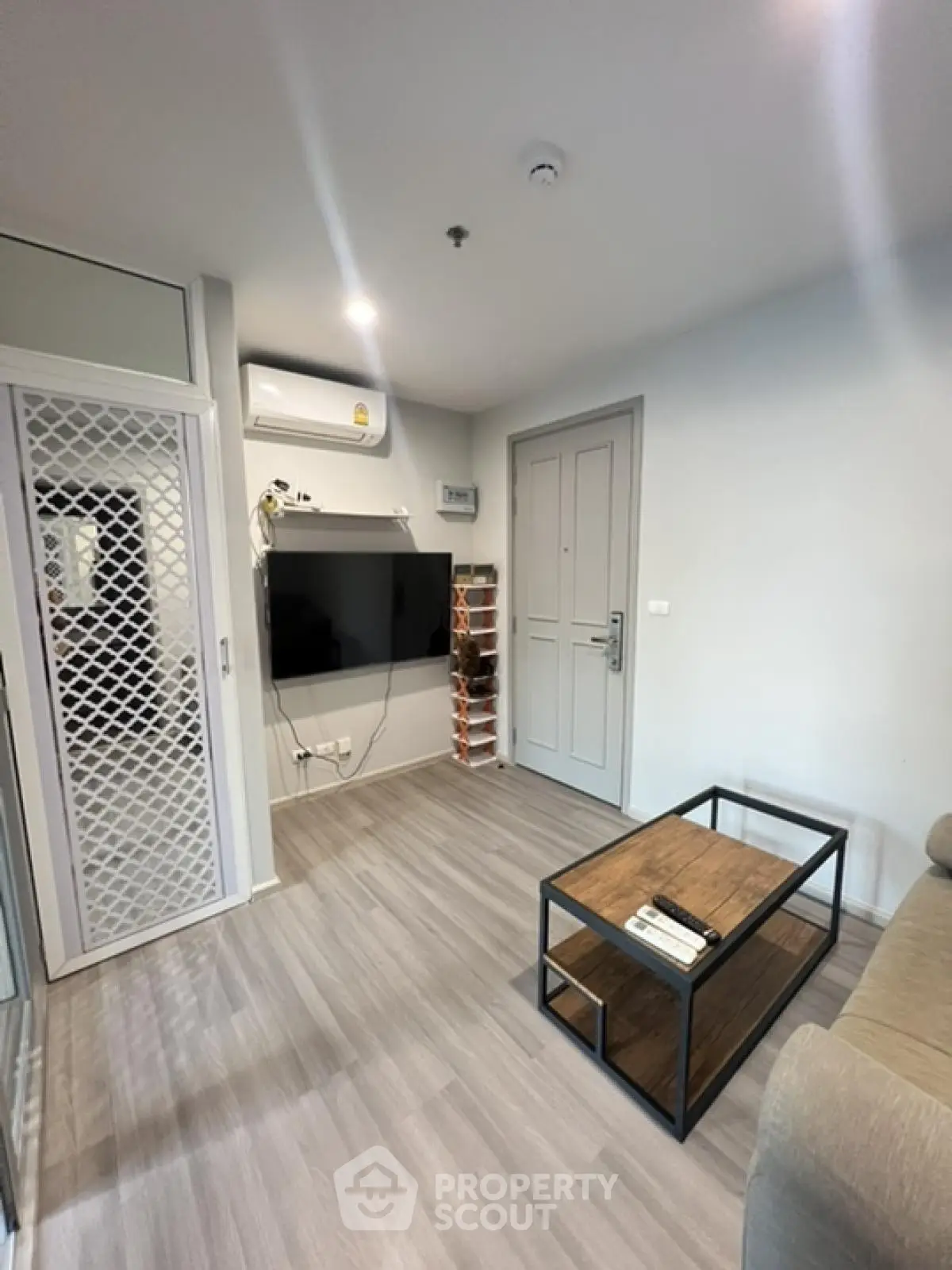 Modern living room with sleek design and wall-mounted TV in a stylish apartment.