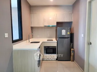 Modern kitchen with sleek appliances and stylish cabinetry in a compact layout.