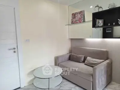 Cozy living room with modern sofa and glass coffee table, perfect for relaxation.