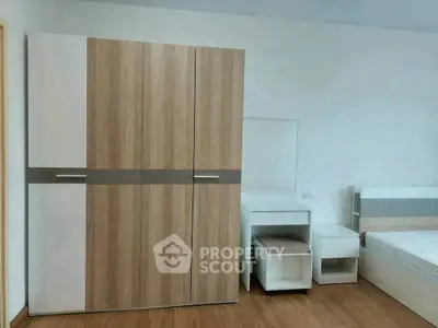 Modern bedroom with sleek wooden wardrobe and minimalist furniture design.