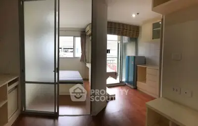Modern studio apartment with wooden flooring and balcony access