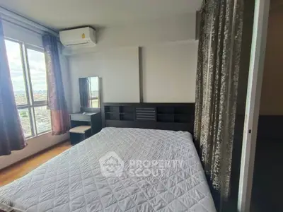 Spacious bedroom with city view, featuring modern furniture and large windows for natural light.