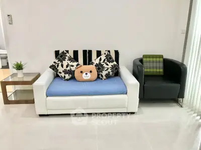 Modern living room with stylish sofa and armchair, perfect for cozy relaxation.