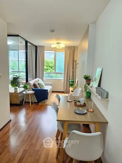 Charming open-plan living and dining area with natural light and modern decor, perfect for urban living.