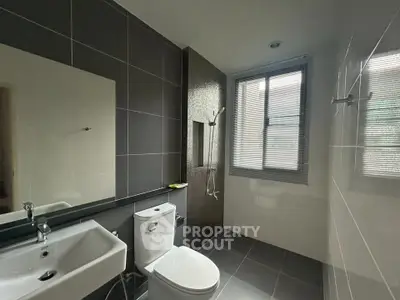 Modern bathroom with sleek design, featuring a shower area and contemporary fixtures.