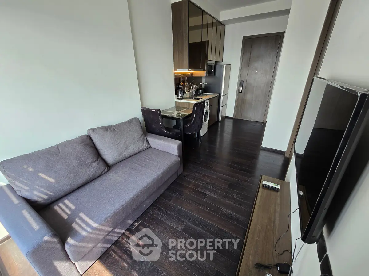 Modern open-layout living room with sleek kitchen and cozy sofa, perfect for urban living.