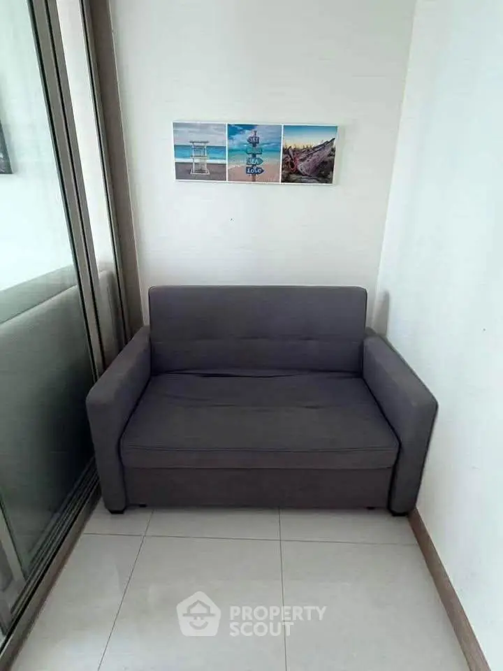 Cozy corner with a modern gray sofa and decorative wall art, perfect for relaxation.
