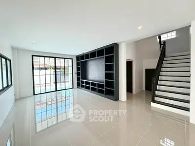 Spacious modern living room with sleek staircase and large windows