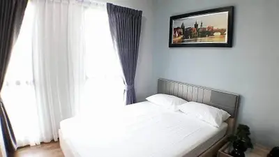 Cozy bedroom with elegant curtains and framed artwork, perfect for relaxation.