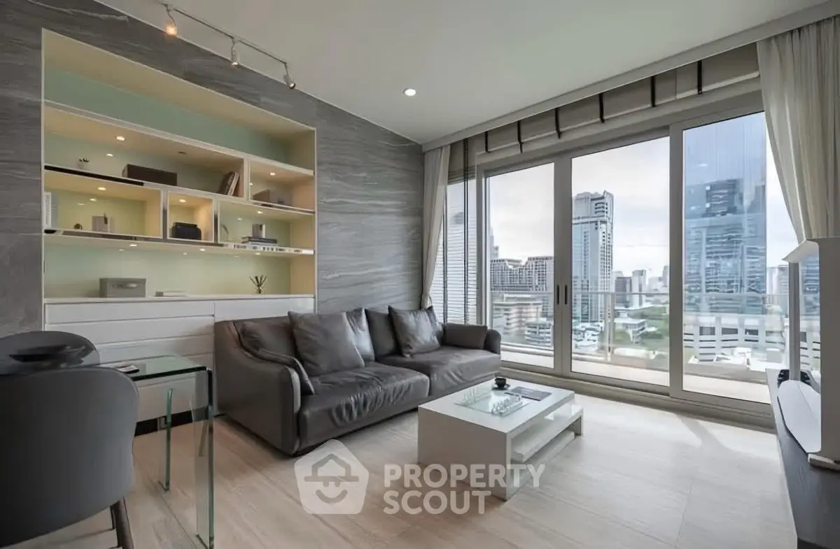 Modern living room with city view, sleek furniture, and built-in shelving.
