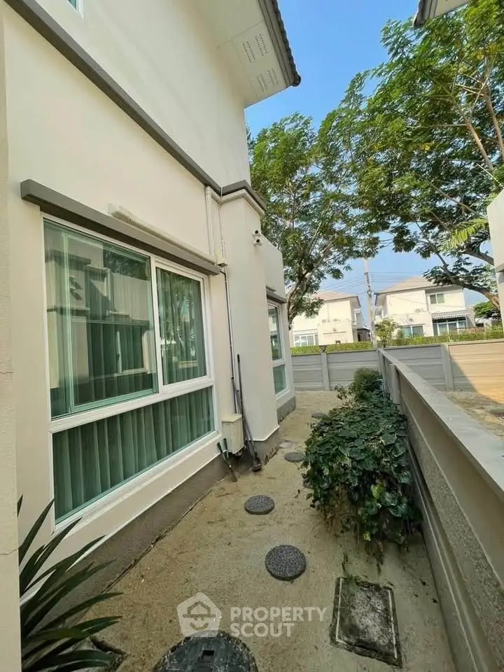 Charming residential exterior with lush greenery and modern architecture, perfect for serene living.