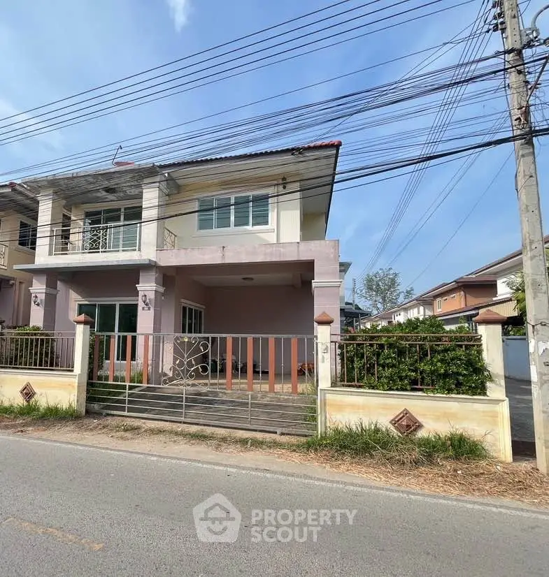 Charming two-story house with gated entrance and spacious balcony in a serene neighborhood.