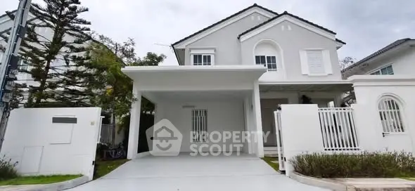 Elegant white two-story house with spacious driveway and modern design.