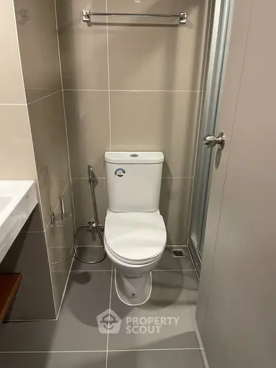 Modern bathroom with sleek toilet and neutral tiles