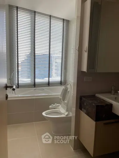 Modern bathroom with large window and bathtub in high-rise apartment