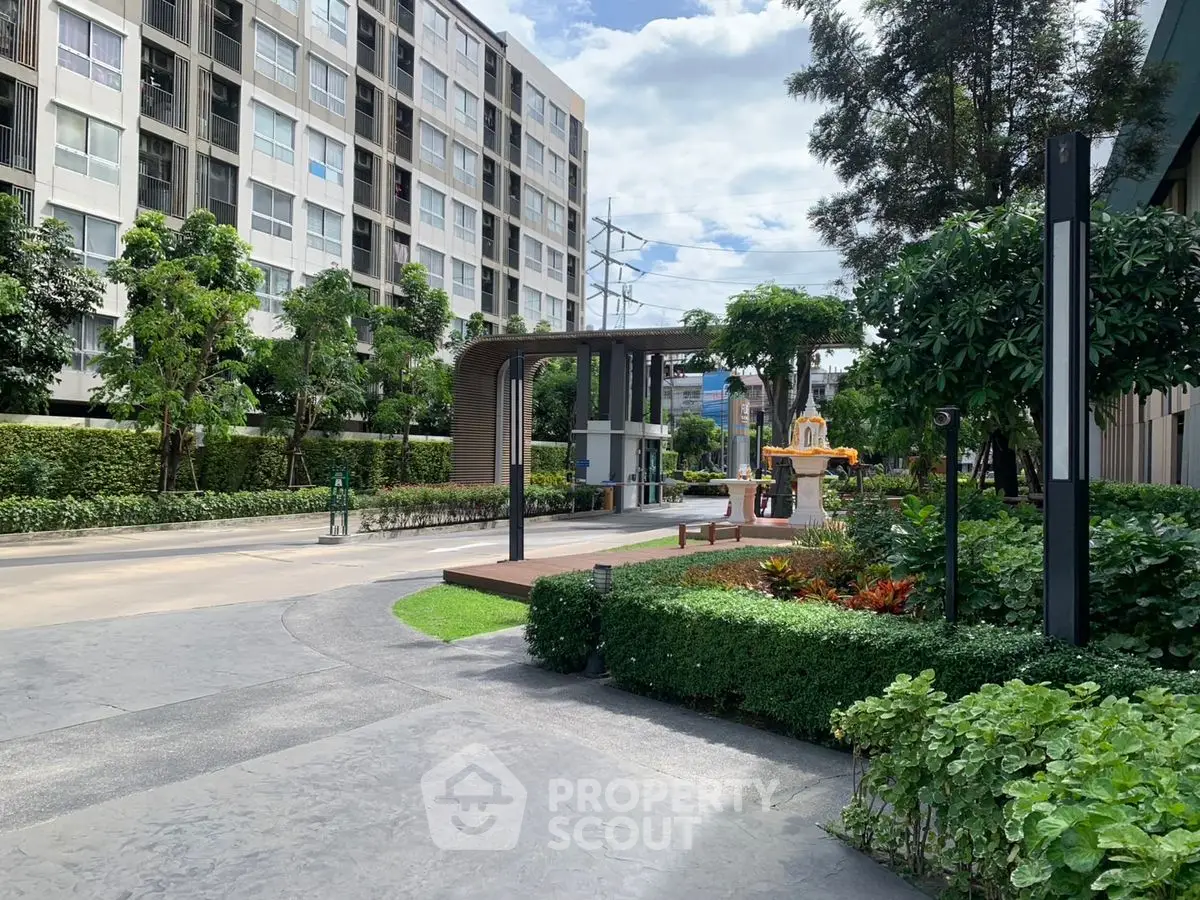 Modern residential building with lush garden and pathway in urban setting