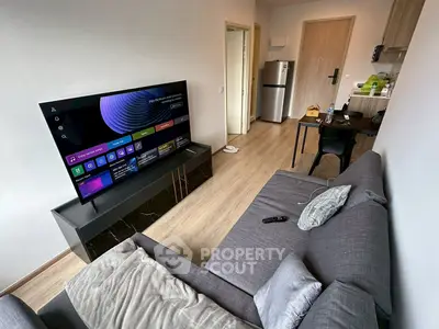 Modern living room with sleek TV setup and cozy gray sofa in a stylish apartment.