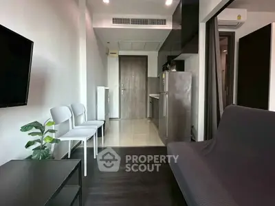 Modern apartment interior with sleek kitchen and cozy living area, featuring stylish furniture and contemporary design.