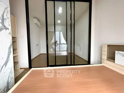 Modern minimalist bedroom with sliding glass doors and wooden flooring