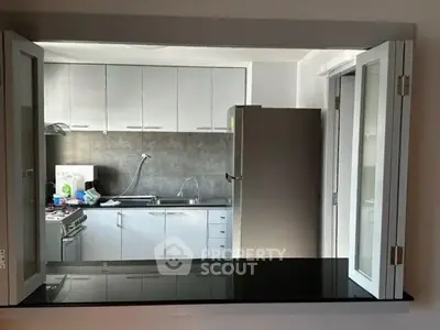 Modern kitchen with sleek cabinets and stainless steel appliances in open layout.