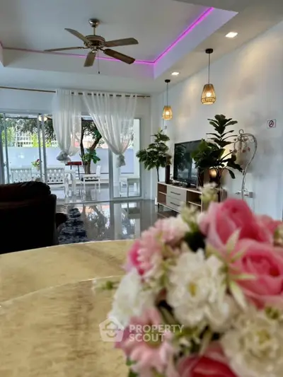 Spacious living room with modern decor and garden view, perfect for relaxation and entertainment.