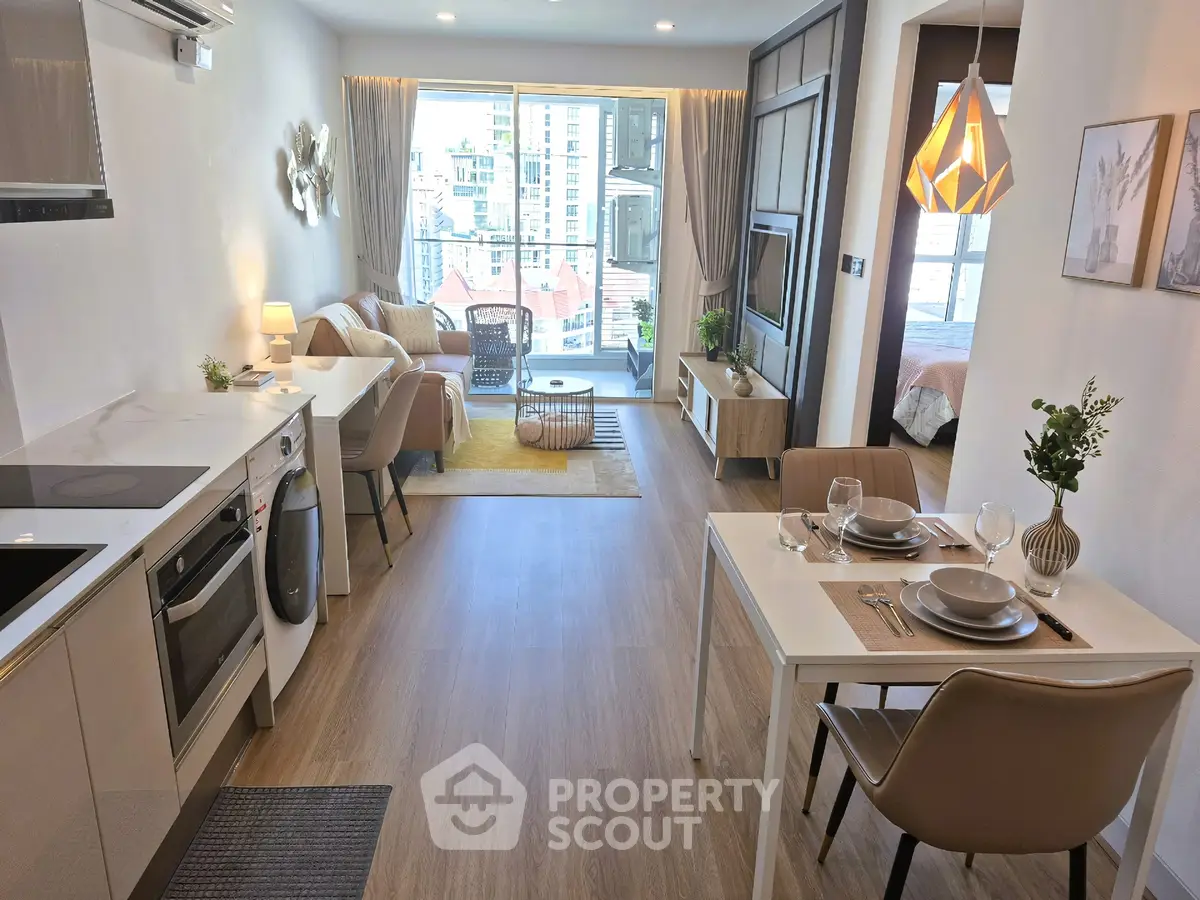 Modern open-plan living room and kitchen with stylish decor and city view.