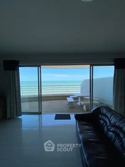 Spacious living room with stunning ocean view and large balcony access.
