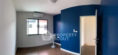 Modern empty room with blue accent wall and wooden flooring