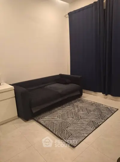 Cozy living room with modern black sofa and stylish geometric rug