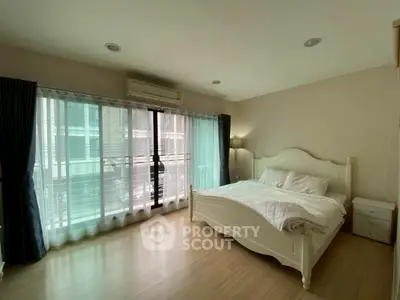 Spacious bedroom with large windows and elegant bed in modern apartment