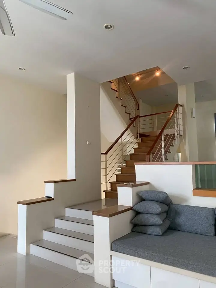 Modern interior with stylish staircase and cozy seating area in a spacious living room.