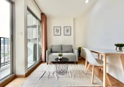 Modern living room with balcony view, stylish decor, and natural light.