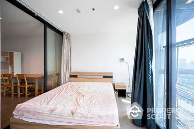 Spacious bedroom with large windows offering ample natural light and city views, seamlessly connected to an open dining area, perfect for modern living.