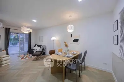 Modern living room with stylish dining area and cozy seating, featuring elegant lighting and contemporary decor.