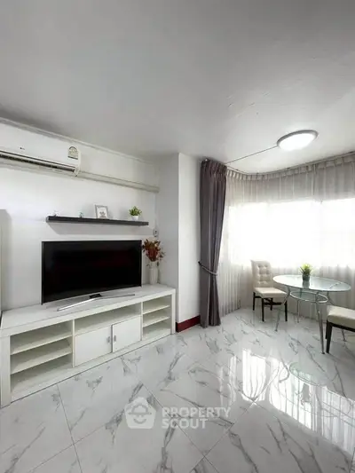 Bright and modern living room with marble flooring and sleek furniture.