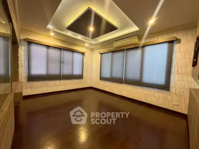 Spacious modern living room with elegant ceiling design and large windows.