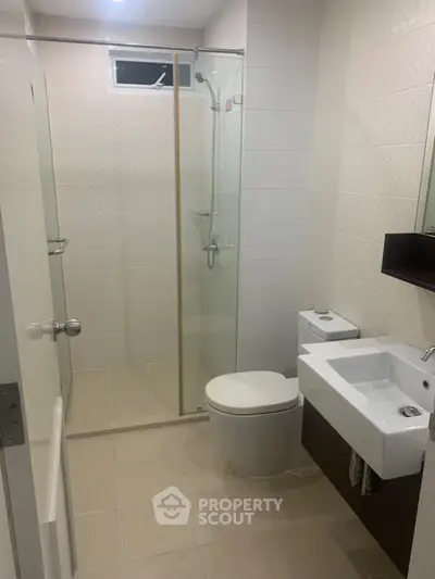Modern bathroom with glass shower enclosure and sleek fixtures