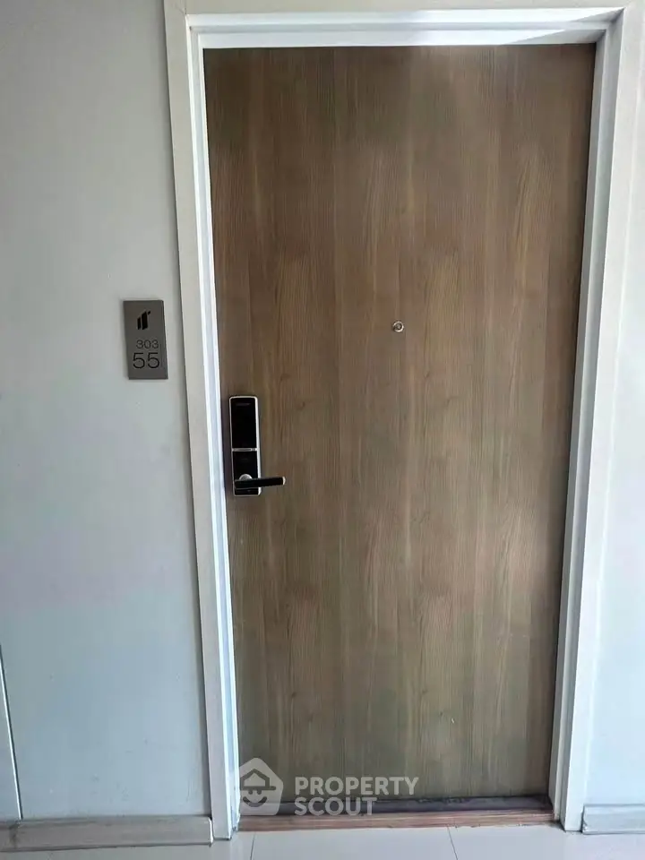Modern apartment entrance with sleek wooden door and digital lock