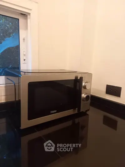 Modern kitchen with sleek microwave and glossy black countertop