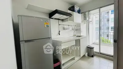 Modern kitchen with balcony view, featuring sleek appliances and ample storage space.