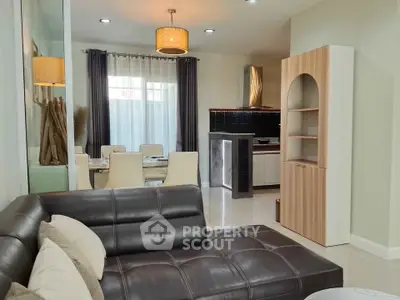 Modern living room with leather sofa and open kitchen layout