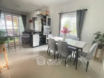 Spacious living and dining area with modern decor and large windows for natural light.